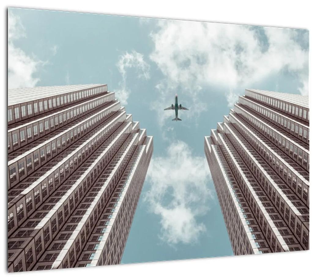 Sklenený obraz lietadla medzi budovami (70x50 cm)