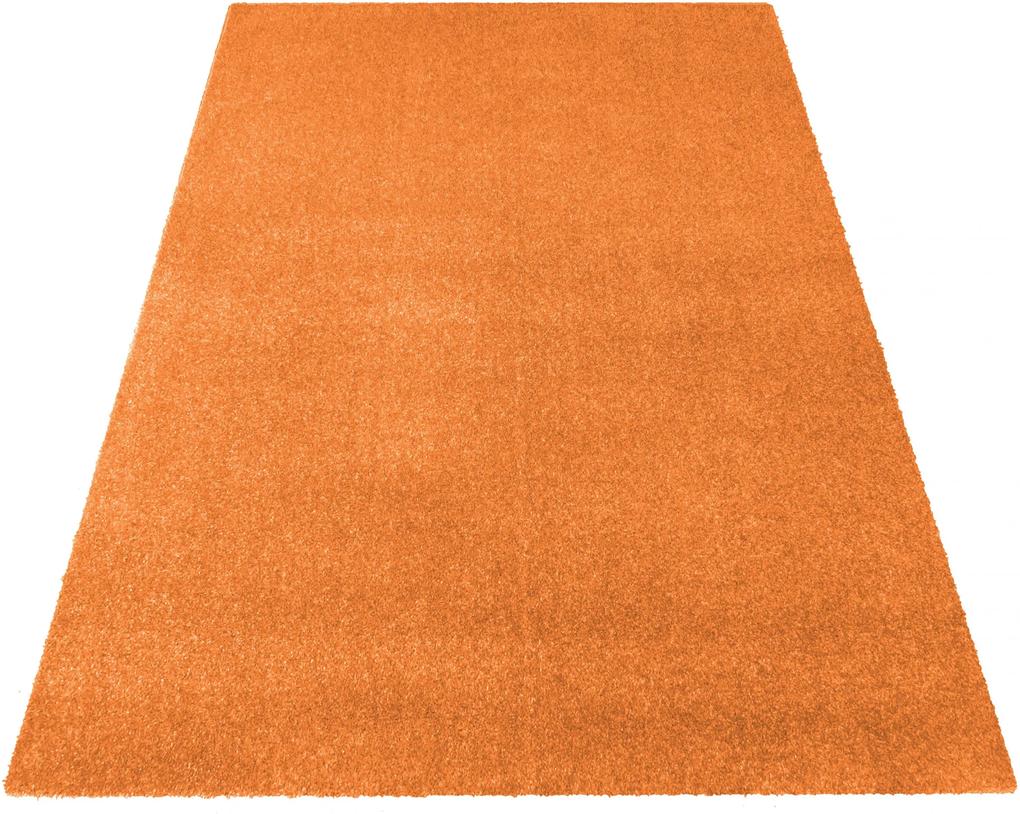 Jednofarebný koberec oranžovej farby