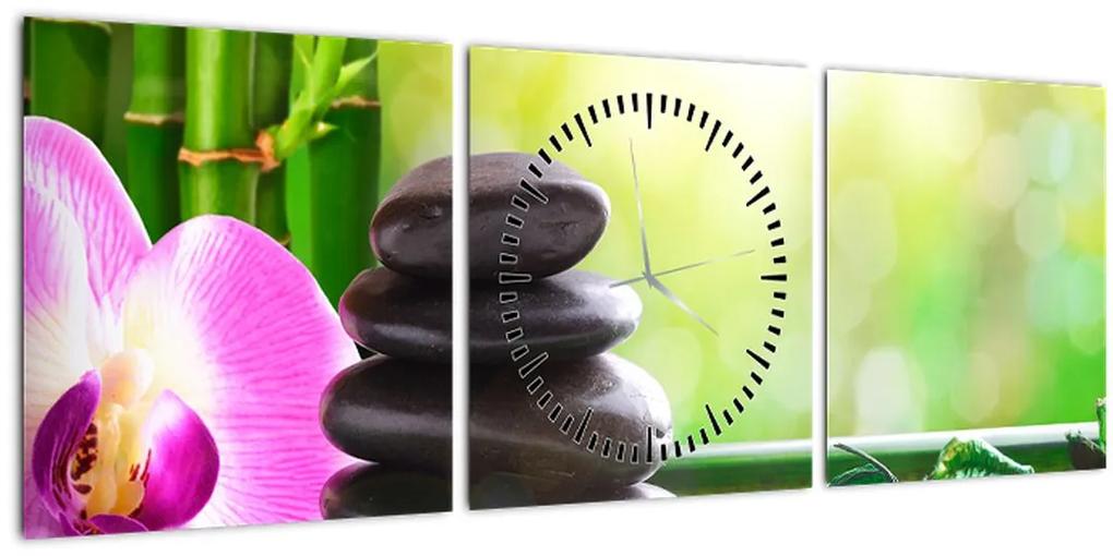 Obraz masážnych kameňov a orchidey na vode (s hodinami) (90x30 cm)