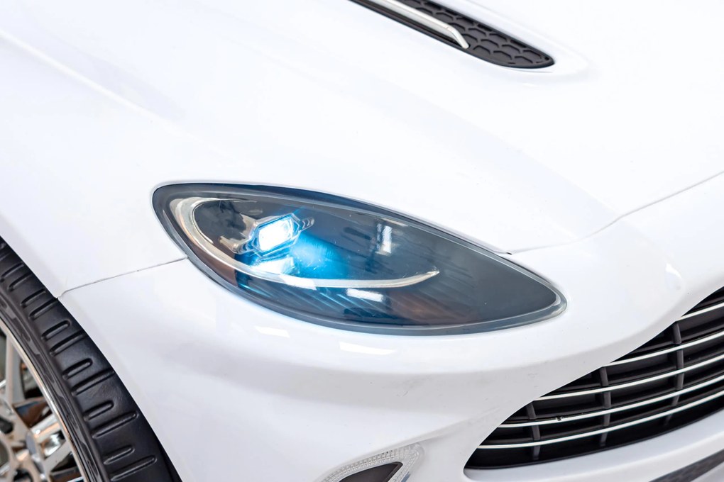 Ramiz Aston Martin DBX na batérie pre deti Biely + diaľkové ovládanie + EVA + pásy + pomalý štart + LED zvuk