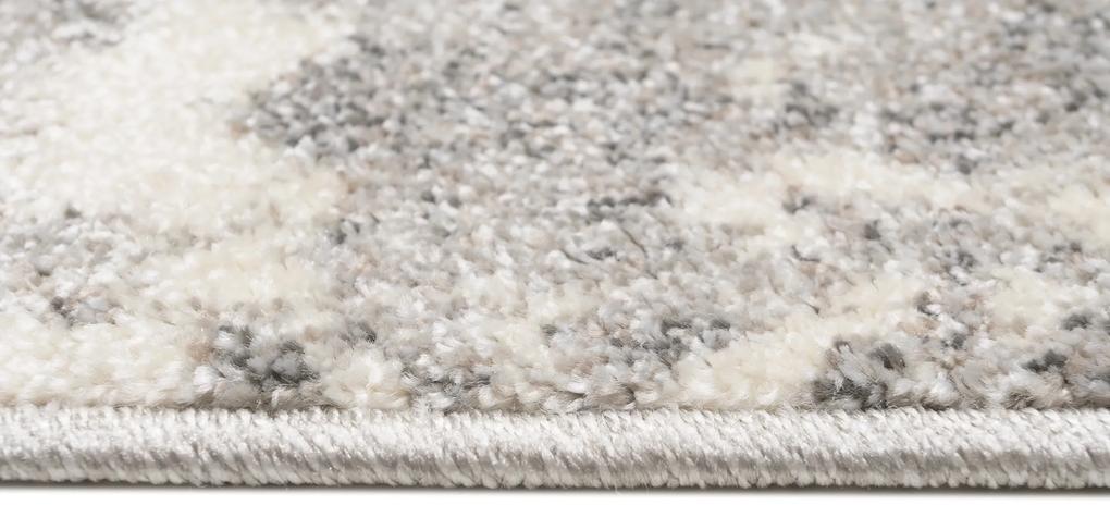 Krémový dizajnový koberec so sivým abstraktným vzorom