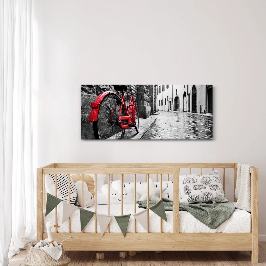 Obraz červeného kolesa na dláždenej ulici (120x50 cm)
