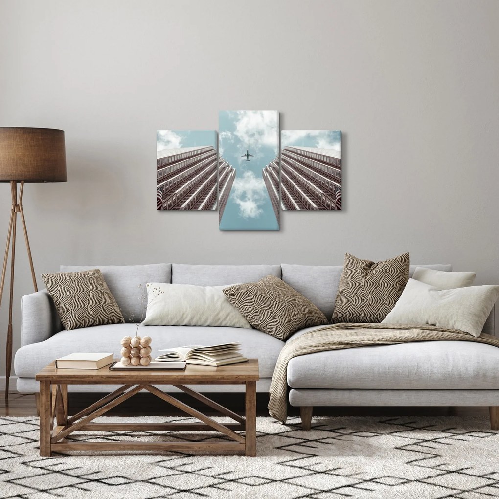 Obraz lietadla medzi budovami (90x60 cm)