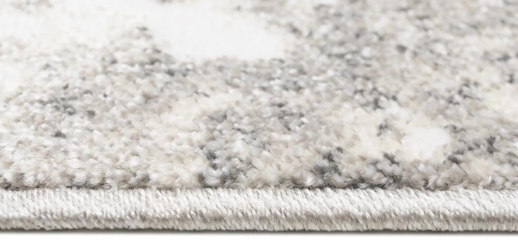 Dizajnový koberec s abstraktným vzorom v krémovej farbe
