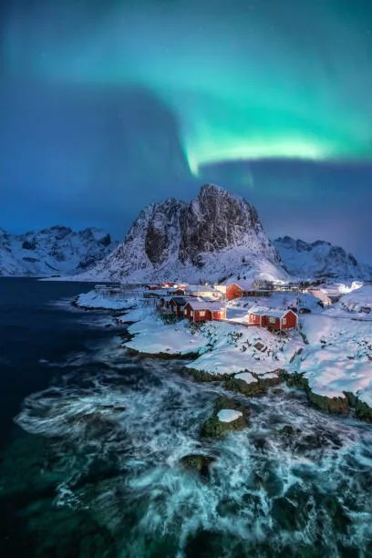 Umelecká fotografie Northern lights over snowcapped mountain, village, Natthawat, (26.7 x 40 cm)