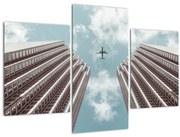 Obraz lietadla medzi budovami (90x60 cm)