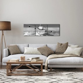Obraz - Lietadlo v oblakoch, čiernobiele (s hodinami) (90x30 cm)