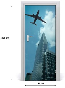 Fototapeta samolepiace dvere lietadlo nad mestom 85x205 cm