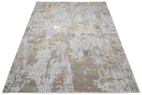 Moderný koberec sivej farby so zlatým motívom