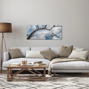 Obraz zasneženého stromu pri vode (120x50 cm)