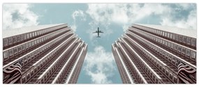 Obraz lietadla medzi budovami (120x50 cm)