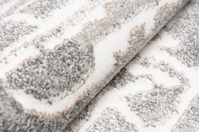 Sivý dizajnový koberec so svetlým abstraktným vzorom