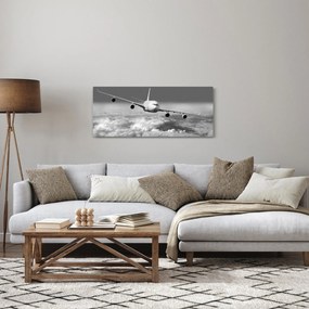 Obraz - Lietadlo v oblakoch, čiernobiele (120x50 cm)
