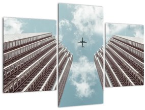 Obraz lietadla medzi budovami (90x60 cm)