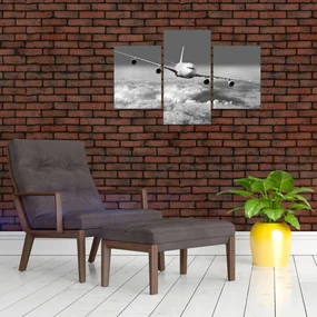 Obraz - Lietadlo v oblakoch, čiernobiele (90x60 cm)