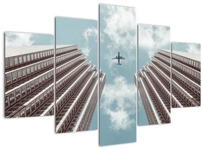 Obraz lietadla medzi budovami (150x105 cm)